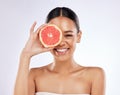 Natural ingredients are the way to go. a beautiful young woman covering her eye with a grapefruit against a studio Royalty Free Stock Photo