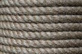 Natural jute hemp rope rolled into a coil, closeup. Brown spool of linen rope texture on the background