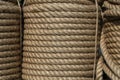 Natural jute hemp rope rolled into a coil, closeup. Brown spool of linen rope texture on the background