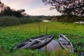 Natural landscape with boats in the water at sunset. Amazing lake with small artisanal fishing boats. Sunrise light reflected in w