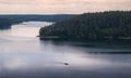 Natural landscape view from above the lake and trees with the sailing boat, reflections on the water and dramatic sky