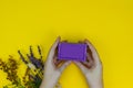 Natural Lavander soap in hands with dried aroma Lavander and flowers on the yellow background