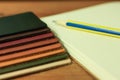 Natural leather samples variety shades of colors with notebook and pencil on wood table, designer concept. Royalty Free Stock Photo