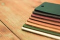 Natural leather samples variety shades of colors on wood table. Royalty Free Stock Photo