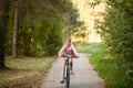 Little girl is riding the bicycle looking in the camera and smiling in the park at evening Royalty Free Stock Photo