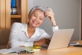 Natural lifestyle office portrait of attractive and happy successful mature Asian woman working at laptop computer desk smiling Royalty Free Stock Photo