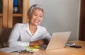 Natural lifestyle office portrait of attractive and happy successful mature Asian woman working at laptop computer desk smiling Royalty Free Stock Photo