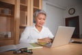 Natural lifestyle office portrait of attractive and happy successful mature Asian woman working at laptop computer desk smiling Royalty Free Stock Photo