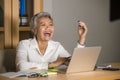 Natural lifestyle office portrait of attractive and happy successful mature Asian woman working at laptop computer desk smiling Royalty Free Stock Photo