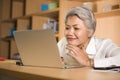 Natural lifestyle office portrait of attractive and happy successful mature Asian woman working at laptop computer desk smiling Royalty Free Stock Photo