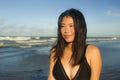 Natural lifestyle portrait of young attractive and happy Asian Korean woman in swimsuit walking on beautiful beach paradise Royalty Free Stock Photo