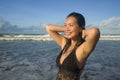 Natural lifestyle portrait of young attractive and happy Asian Korean woman in swimsuit walking on beautiful beach paradise Royalty Free Stock Photo