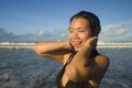 Natural lifestyle portrait of young attractive and happy Asian Korean woman in swimsuit walking on beautiful beach paradise Royalty Free Stock Photo