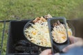 natural light. barbecue. a frying pan is used for cooking. fire. firewood. the girl takes pictures on the phone Royalty Free Stock Photo