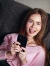 Natural light close up lifestyle portrait of beautiful blond woman with blue eyes long hair on sofa looking at camera Royalty Free Stock Photo