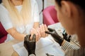 Professional nail artist in black gloves making natural manicure