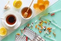 Natural medicine, tea, honey, lemon and garlic against tablets of syringes and other medications, top view background in two color