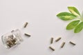 Natural medicine capsules in open glass jar lying on table Royalty Free Stock Photo