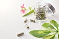 Natural medicine capsules in open glass jar on table elevated Royalty Free Stock Photo