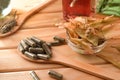 Natural medicine capsules on wooden spoon on table elevated Royalty Free Stock Photo