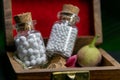 Natural medicine concept - Homeopathic pills in vintage glass bottles in wooden old box with flower petal and wild fruit on dark