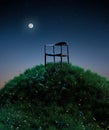 Natural moon night field of fresh grass environment, little hill meadow with wooden chair. lonely concept Royalty Free Stock Photo