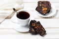 Natural morning drink chicory in a white Cup and saucer with pieces of fruit nut bread