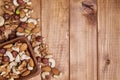 Natural nutritious mix of different nuts in a square wooden plate on brown wooden table at the left side. Mixture of walnuts, huze