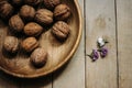 Natural nuts and in a stylish unique rustic bowl on a wooden b