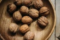 Natural nuts and in a stylish unique rustic bowl on a wooden b