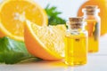 Natural orange essential oil in bottle and cut oranges fruit on white wooden table