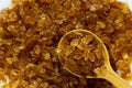 organic brown crystal rock sugar in wooden spoon over brown rock sugar stack Royalty Free Stock Photo