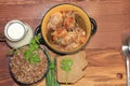Natural organic buckwheat porridge in a clay pot, meat in a pot, a jug of milk and onions with parsley, a modest country breakfast Royalty Free Stock Photo