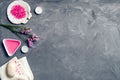 Natural organic cosmetics, rose oil, bath salt and pink flowers on grey stone background, top view, copy space Royalty Free Stock Photo