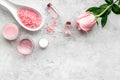 Natural organic cosmetics with rose oil. Cream, lotion, spa salt on grey background top view copyspace Royalty Free Stock Photo