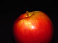 Natural organic healthy fruit. Close up of a ripe red juicy apple on black background. Royalty Free Stock Photo