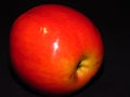 Natural organic healthy fruit. Close up of a ripe red juicy apple on black background. Royalty Free Stock Photo