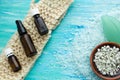 Natural organic soap bottles essential oil and sea salt herbal bath on a blue wooden table, with flowers Royalty Free Stock Photo