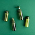 Natural organic SPA beauty products set on green background. Top view green cosmetic bottles, packaging design