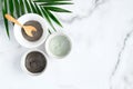 Natural organic SPA clay facial mask in bowls and tropical leaf on marble background. Face skin care and beauty treatment concept Royalty Free Stock Photo