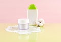 Natural organic SPA cosmetic products set with dried cotton flower. Side view of skin care beauty products on green pink