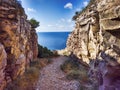 Natural path of a cliff between rocks smoothed by the wind until a ravine over deep blue sea