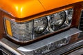 Close-up of the round headlamps of a orange american classic car. Royalty Free Stock Photo