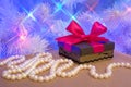 Natural pearl garland and a gift wrapped present with red bow