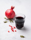 Natural pomegranate juice in a glass on a light background with fresh fruit. A healthy freshly squeezed drink with vitamins and