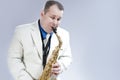 Natural Portrait of Expressive Male Saxophone Musician Performing in White Suit