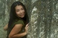 Natural portrait of young beautiful and happy Asian Chinese woman in green Summer dress  posing playful against rocky mountain Royalty Free Stock Photo