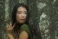 Natural portrait of young beautiful and happy Asian Korean woman in green Summer dress  posing playful against rocky mountain Royalty Free Stock Photo