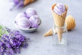 Natural purple ice cream in waffles cone with flowers on gray background. Frozen Dessert. Healthy food Royalty Free Stock Photo