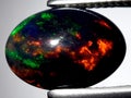 natural rainbow black opal gemstone on the background Royalty Free Stock Photo
